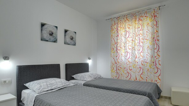 A double room with two beds, a white wall, and a colorful curtain. - Villa in Marcana With Pool and Adriatic Views (Marcana)