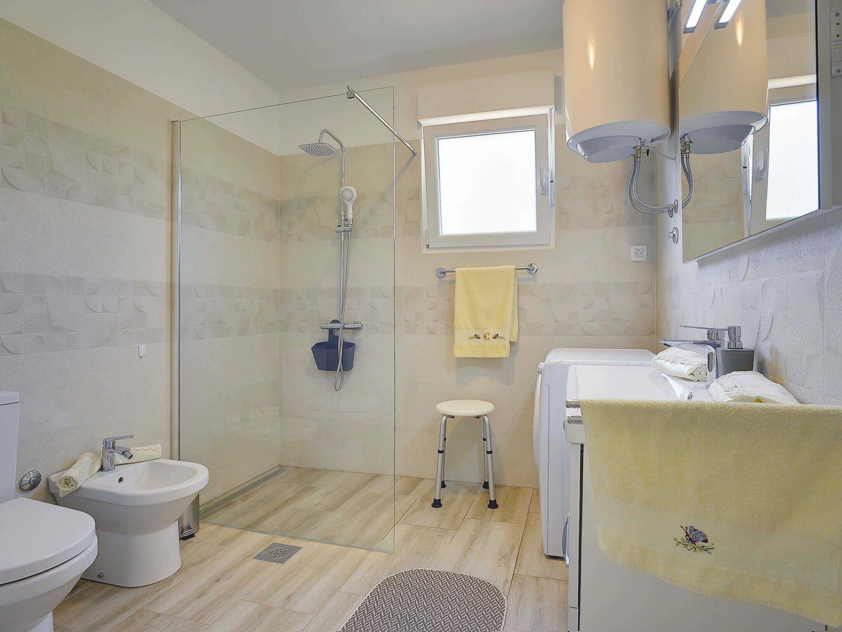 A modern bathroom with a shower, bidet, toilet, and a sink.