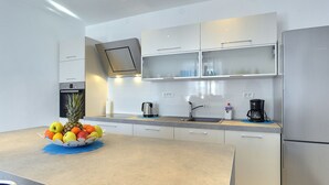 A modern kitchen with a built-in oven, a stainless steel refrigerator, and a fruit bowl on the counter. - Holiday Home in Liznjan Near the Beach (Liznjan)