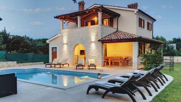 Ein zweistöckiges Haus mit Swimmingpool, Außenbereich und einer Terrassenfläche.