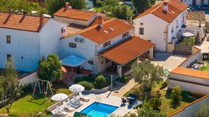 A residential area with a swimming pool, outdoor seating, and a garden. - Holiday Home in Segotici With Private Pool (Marcana)