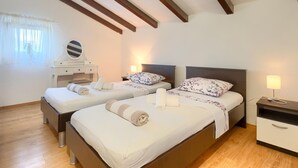 A bedroom with two beds, a vanity with a mirror, and a nightstand with a lamp. - Holiday Home in Segotici With Private Pool (Marcana)