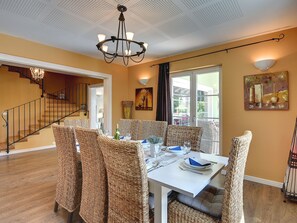A dining area with wicker chairs, a white table, and a chandelier. - Detached Villa With Swimming Pool in the East of Istria Near the Sea (Marcana)