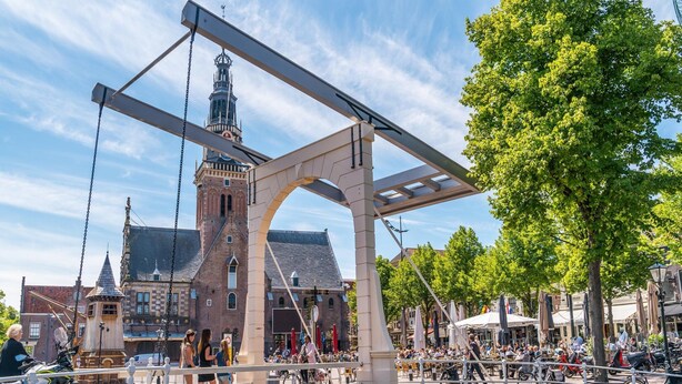 Eine historische Brücke mit Steinbauweise und Metallkonstruktion, die zwei Stadtteile über einen Kanal verbindet.