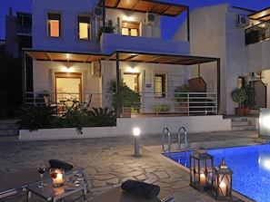 Une maison moderne à deux étages dotée d’une piscine, d’un espace salon extérieur et d’un patio couvert.