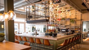 A bar area with a long counter, multiple stools, and a variety of bottles and glasses on shelves. - Spacious Holiday Home on Markermeer near Amsterdam (Uitdam)
