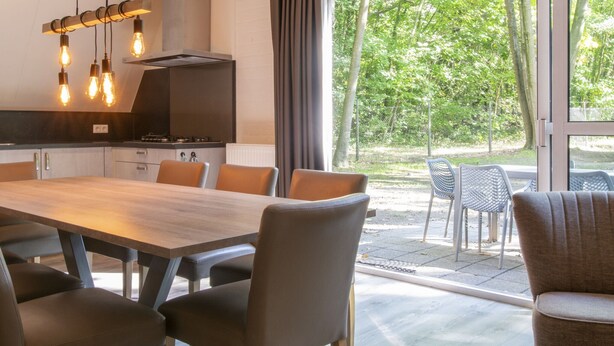 Una cocina moderna con comedor, ventanas amplias y vista a zonas verdes.