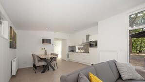 A modern, open-plan living area with a kitchen and dining space. - Modern Lodge With Dishwasher, Near Helmond (Mierlo)