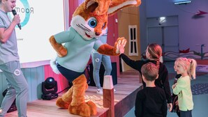 A stage with a person in a rabbit costume, a microphone, and a group of children. - Modern Lodge With Dishwasher, Near Helmond (Mierlo)