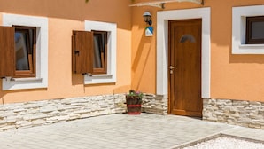 A building with a stone base, a wooden door, and two windows with shutters. - Charming Villa With Private Swimming Pool (Zminj)