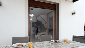 Una mesa de comedor con platos de comida y bebidas, una escalera y un diseño de interiores moderno.