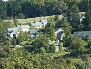 A cluster of houses with sloped roofs, surrounded by dense greenery and trees. - Modern Apartment With Terrace (Durbuy)