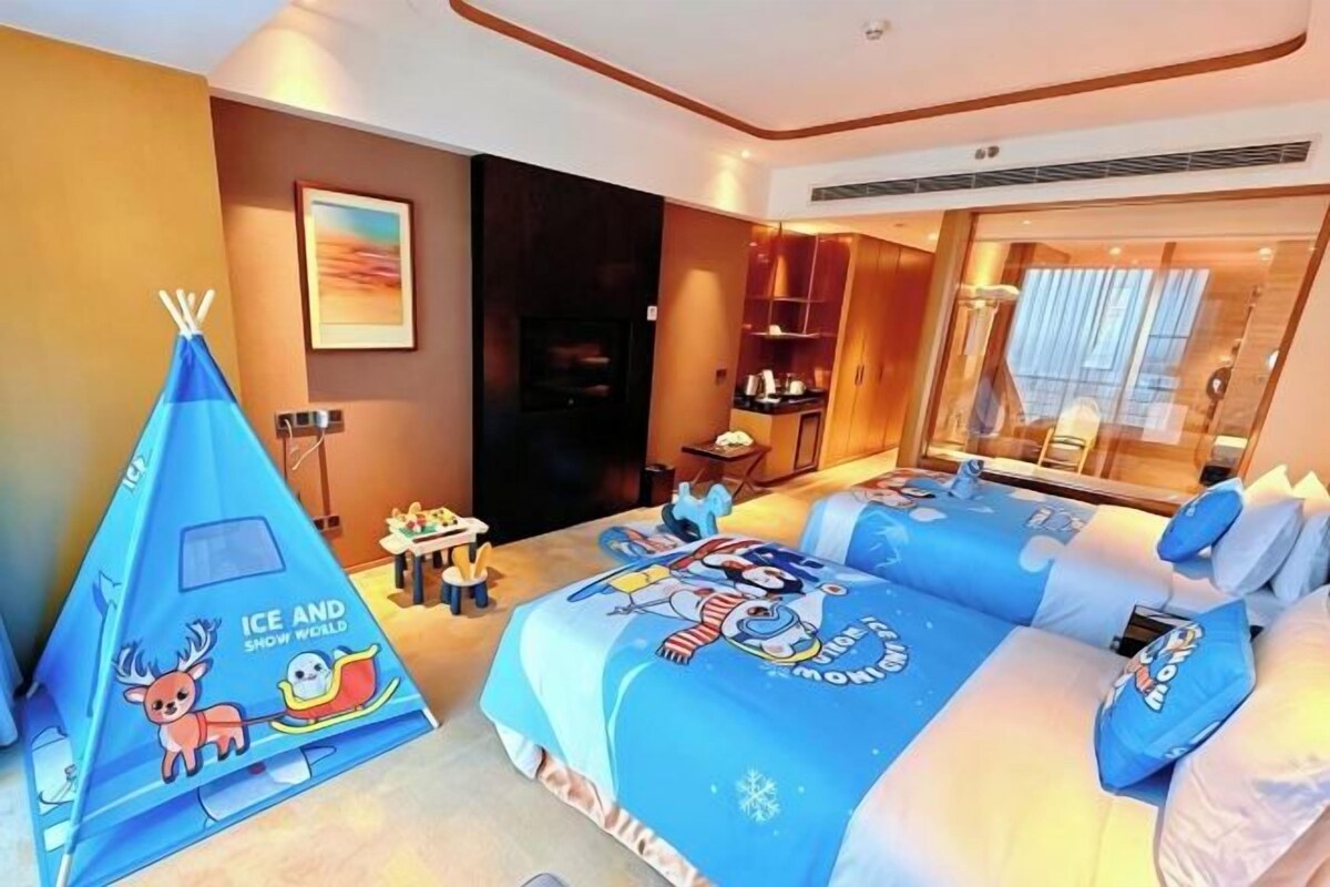 Una camera d'albergo con un letto grande, un tavolino, una sedia, una tenda blu e un quadro appeso al muro.