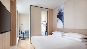 A modern hotel room with a large bed, a flat-screen TV, a sofa, and a painting on the wall. - Fairfield by Marriott Beijing Haidian (Beijing)