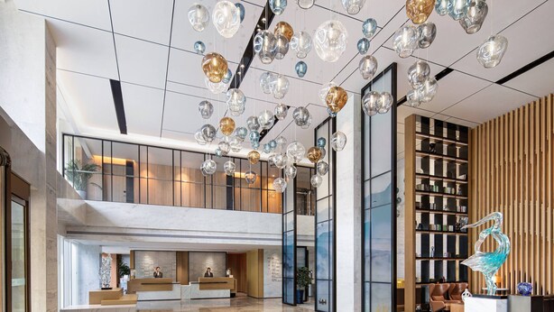 A spacious lobby with a reception desk, a staircase, and a large sculpture. - Fairfield by Marriott Beijing Haidian (Beijing)