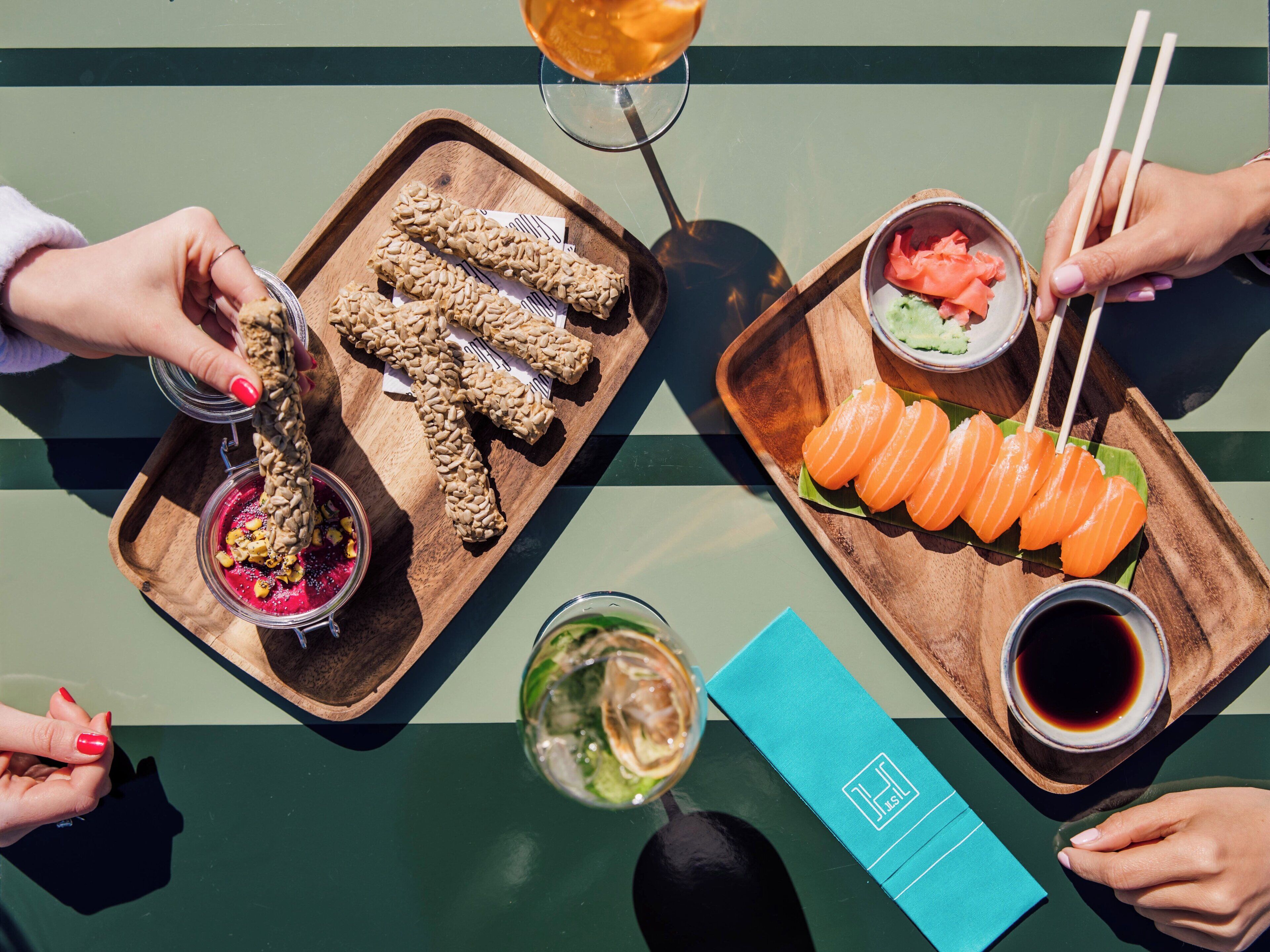 A table with food items, including sushi, a drink, and a dessert.