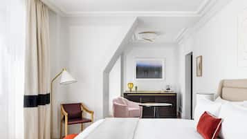 Una habitación de hotel con una cama grande, un escritorio, una silla y un sofá.