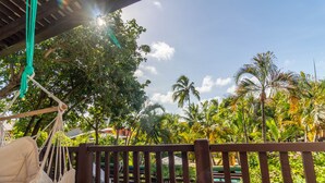 A hammock chair under a wooden pergola with a view of palm trees and a clear sky. - PF08 Ap Duplex 2 Suites - Praia do Forte (Mata de São João)