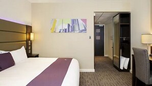 A hotel room with a large bed, a desk, a chair, a wardrobe, and a mirror. - Premier Inn Darlington Town Centre Hotel (Darlington)