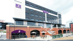 A hotel with multiple floors, a prominent 'Premier Inn' sign, outdoor seating area, and a staircase leading to the entrance. - Premier Inn Darlington Town Centre Hotel (Darlington)