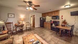 A spacious living room with a wooden coffee table, a fireplace, and a ceiling fan.