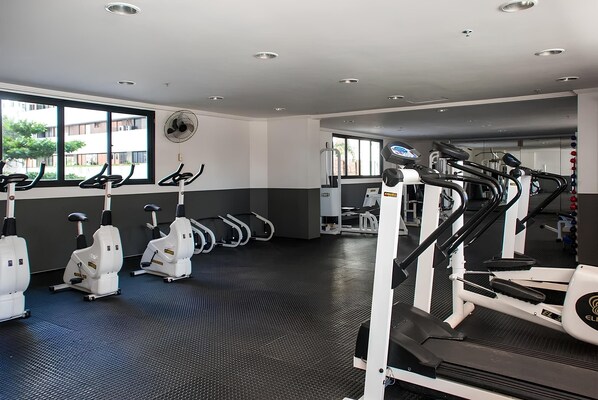 A gym with stationary bikes, treadmills, and weight machines. - Conforto e comodidade na Praia Iracema (Fortaleza)