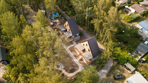 Vista aérea de una zona residencial con varias casas, rodeada de árboles frondosos.