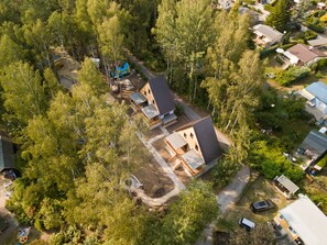 Luchtbeeld van een woongebied met meerdere huizen, omgeven door dichte bomen.