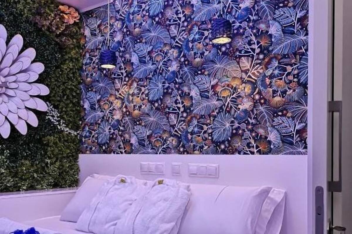 A bedroom with a bed, white pillows, and a blue towel.