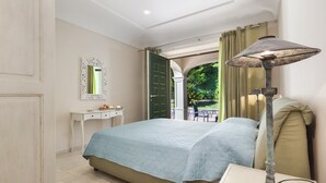 A bedroom with a bed, a bedside table, a lamp, and a view of the outdoors. - Villa Il Noce with Private Pool, SPA, Garden, BBQ and Parking (Sant'Agata sui due Golfi)