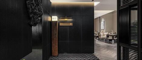 A modern hotel lobby with a reception desk, seating area, and a decorative wall.