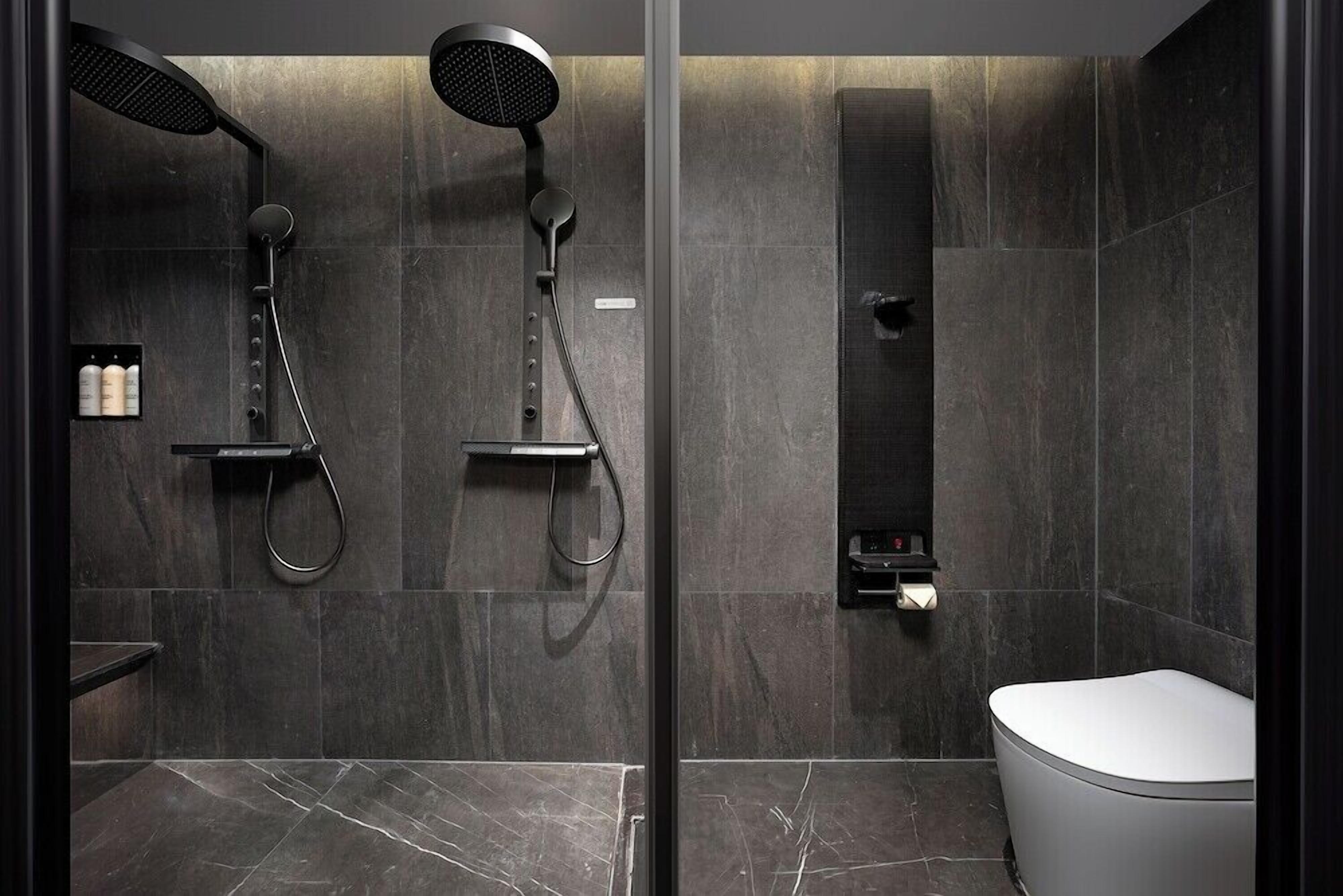 A modern bathroom with a glass shower enclosure, a toilet, and a shelf with toiletries.