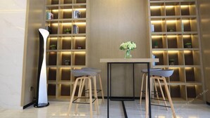 A modern interior with a central table, two bar stools, and a tall floor lamp. - Borrman Hotel (Guangzhou Tianhe Sports Center Linhe West Metro Station) (Guangzhou)