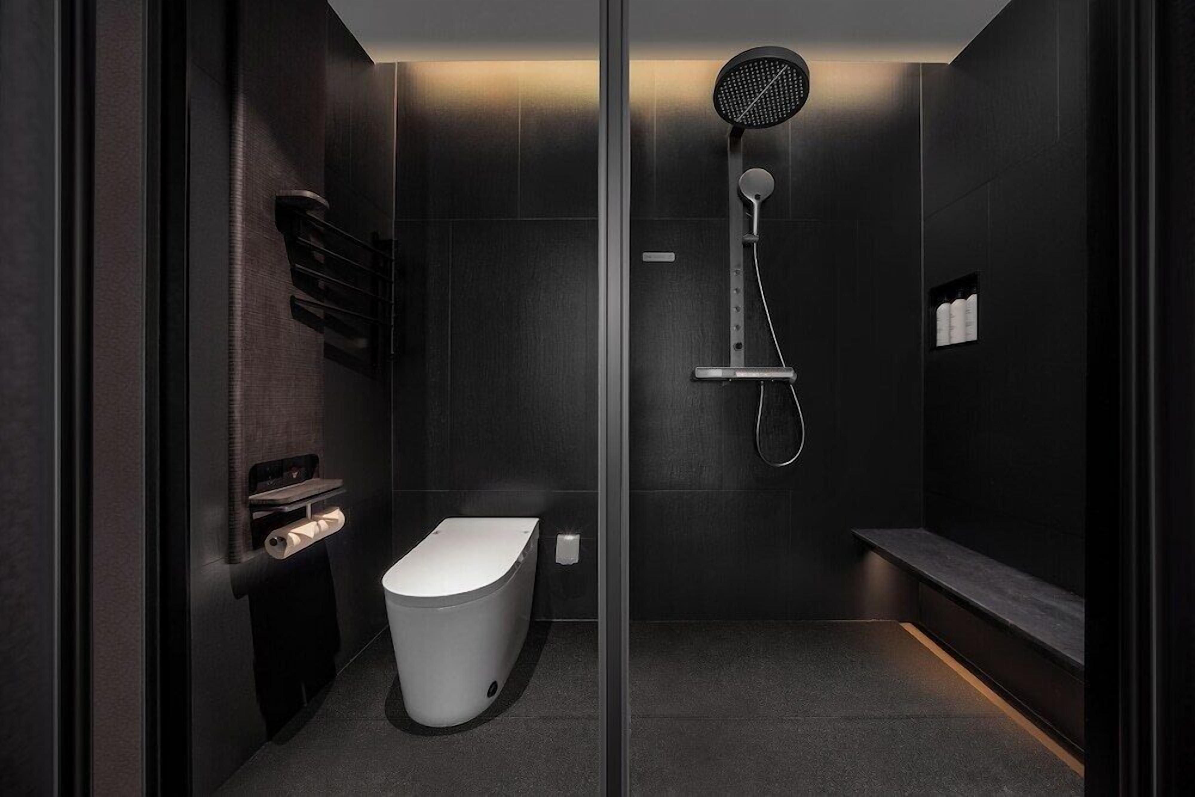 A modern bathroom with a toilet, a shower, and a towel rack.