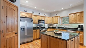 Une cuisine moderne avec des meubles en bois, des appareils en acier inoxydable et un îlot central.