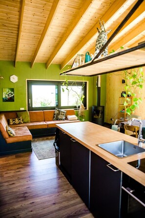 Una cocina moderna con vigas de madera, un banco empotrado y un ventanal grande.