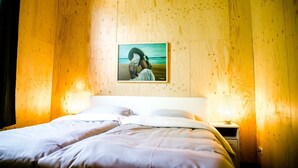 A bed with white linens, a nightstand with a lamp, and a framed picture on the wall. - Nature lodge Ljip, Akkrum - sleeps 6 by the water (Akkrum)
