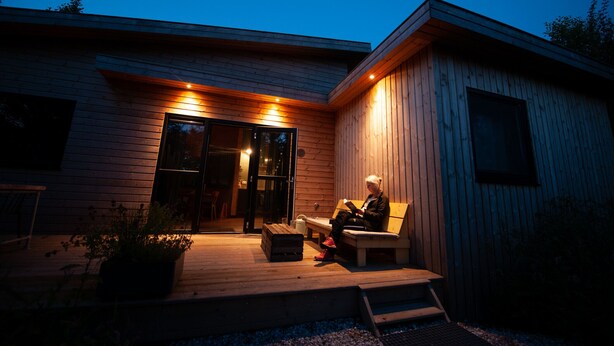 A modern wooden house with a porch, a bench, and a person sitting on the bench reading a book. - Nature lodge Ljurk, Akkrum - sleeps 4, dogs welcome (Akkrum)