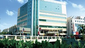 A multi-story building with a modern design, featuring a prominent glass facade and a series of horizontal windows. - Haiyan International Hotel (Jiaxing)