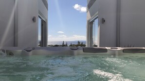Ein Whirlpool mit Blick auf das Meer und die Berge.