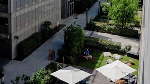 A modern building with a covered outdoor area, including seating and umbrellas. - Slo Bordeaux Hostel (Bordeaux)
