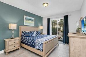 A bedroom with a bed, nightstands, a dresser, and a TV.
