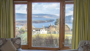 A room with two sofas facing a large window overlooking a scenic landscape. - An Cala - Spacious house with stunning sea-views (Tobermory)