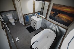 Een bad/douchecombinatie, een haardroger, handdoeken, toiletpapier