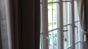 A window with white frames and a view of greenery outside.