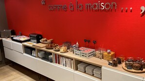 Un buffet de petit-déjeuner proposant une variété d’aliments et un coin café.