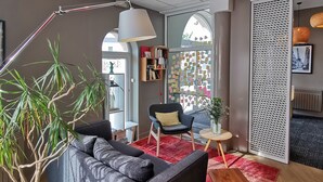 Un salon moderne avec un canapé gris, une table basse et une plante.