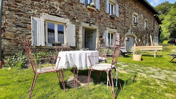 A stone building with a table and chairs set up outside. - The house under the stars (Sembadel)