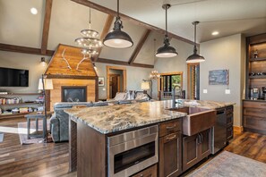 A spacious kitchen with a large island, built-in appliances, and a stone countertop.