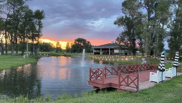 A serene lakeside setting with a wooden deck, a gazebo, and a fountain. - Heavensfield - Family Reunion Center (Rexburg)